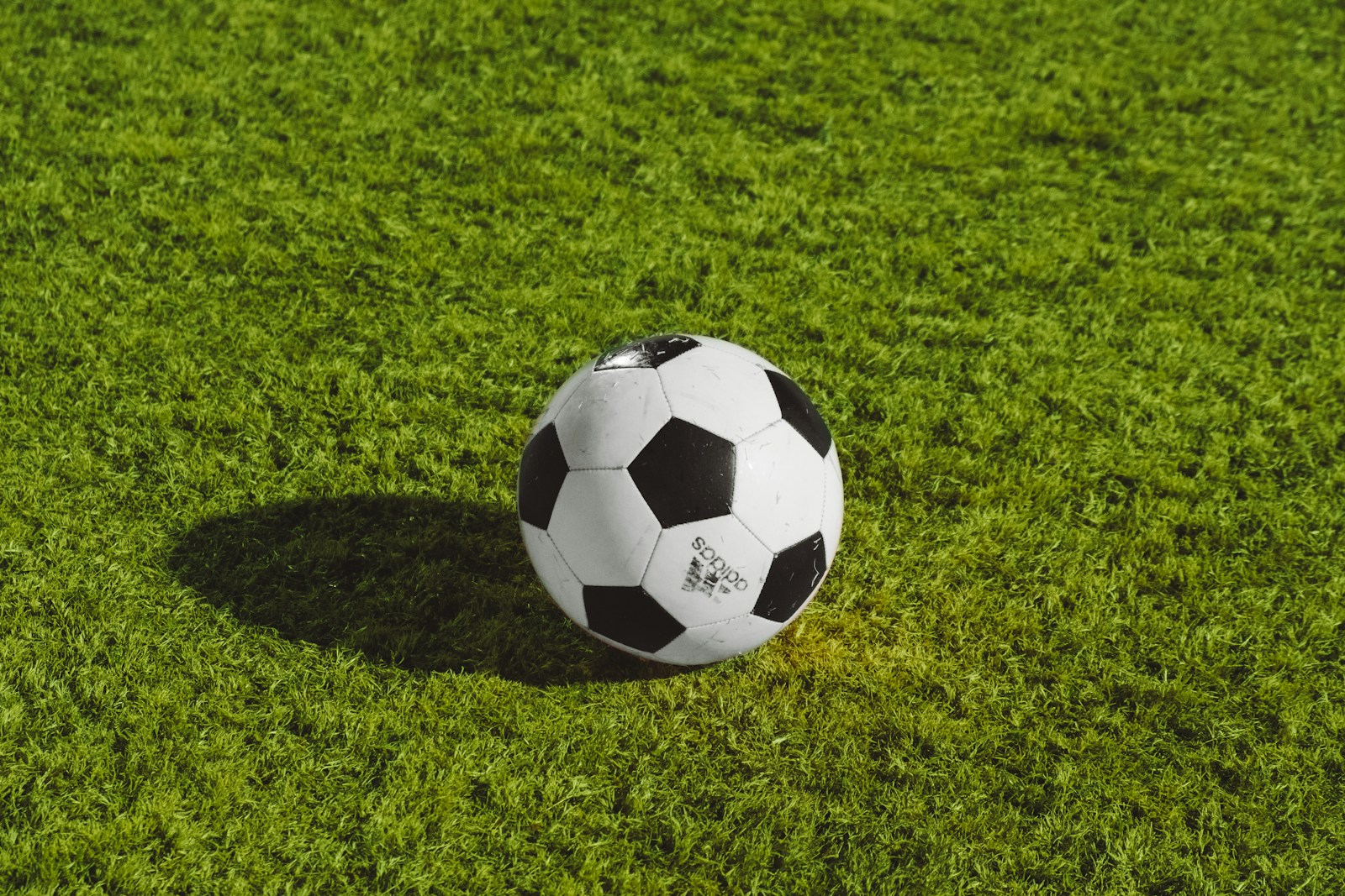 white and black soccer ball on grass field