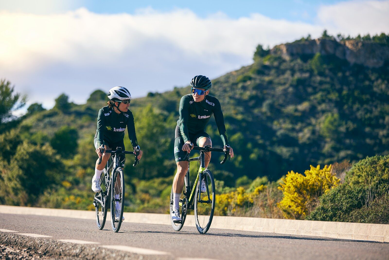 a couple of people riding bikes down a road